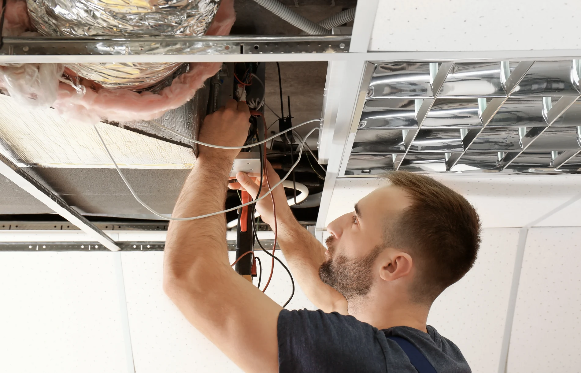 Air conditioning service technician inspecting HVAC equipment